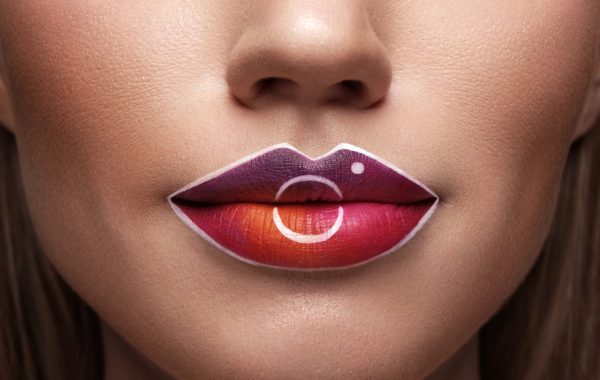 Beautiful caucasian woman with creative makeup in the form of an instagram pattern on her lips. Beauty face. Art makeup